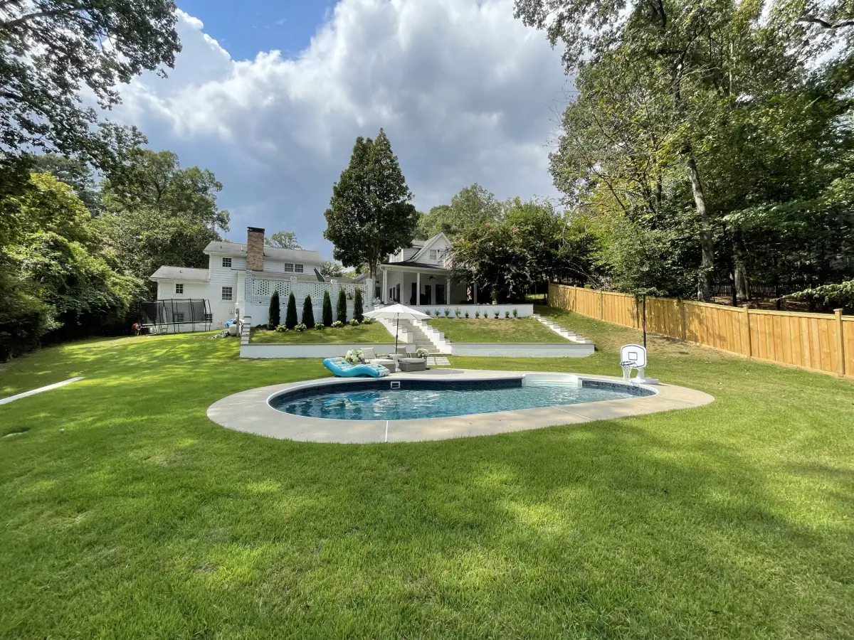 Backyard pool with manicured surrounding lawn